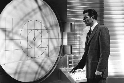 Klaatu inside the spaceship, looking at a panel