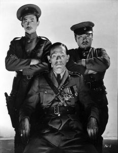 Boris Karloff as General Wu Yen Fang, with his right-hand man Mr. Cheng to one side, and the man who accepted a bribe on the other
