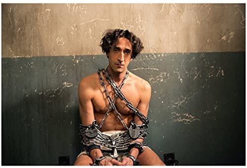 Adrien Brody as Houdini, chained in a cell