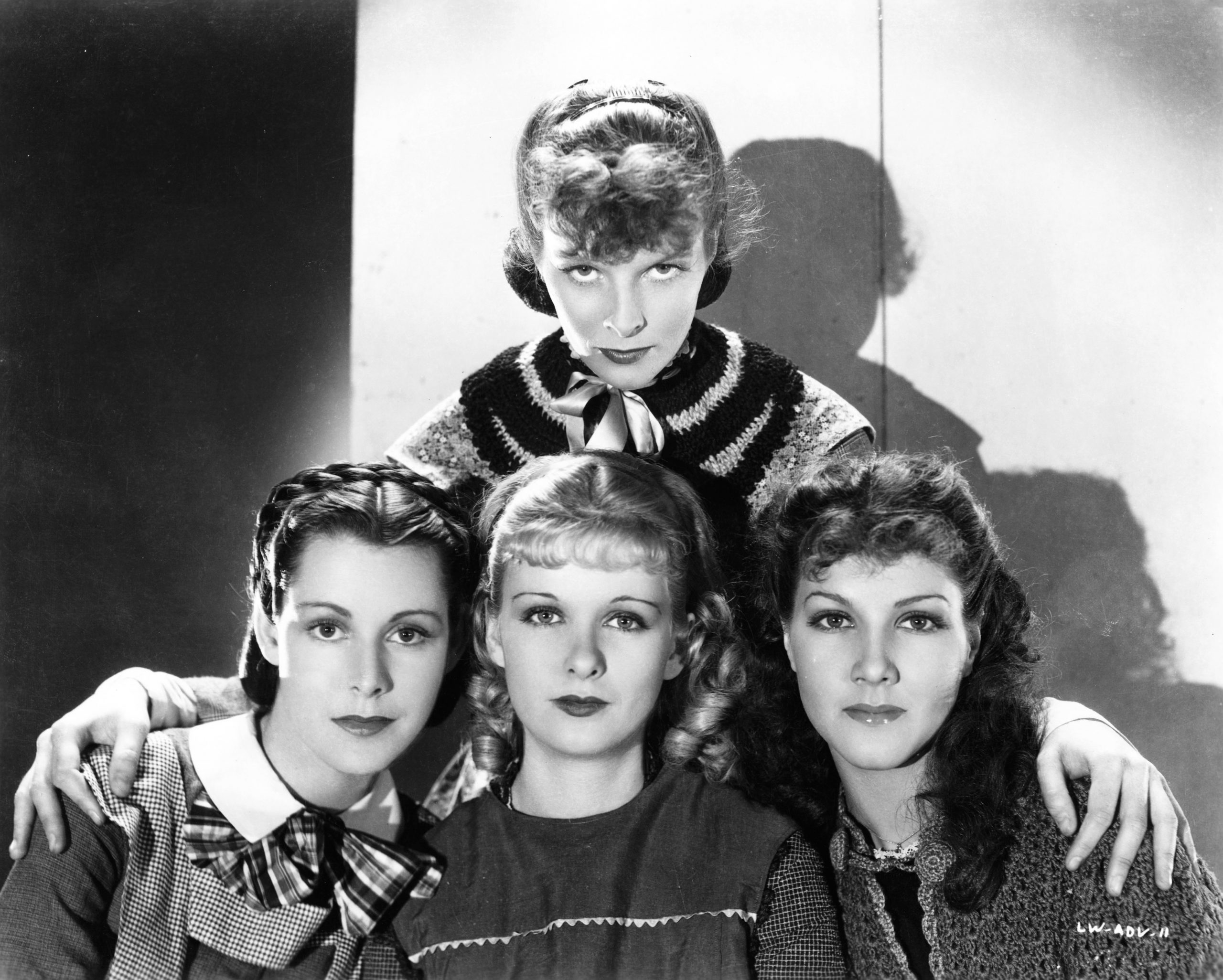 Katharine Hepburn stands behind her on-screen sisters played by Jean Parker, Frances Dee. and Joan Bennett in this publicity still from LITTLE WOMEN (1933) 