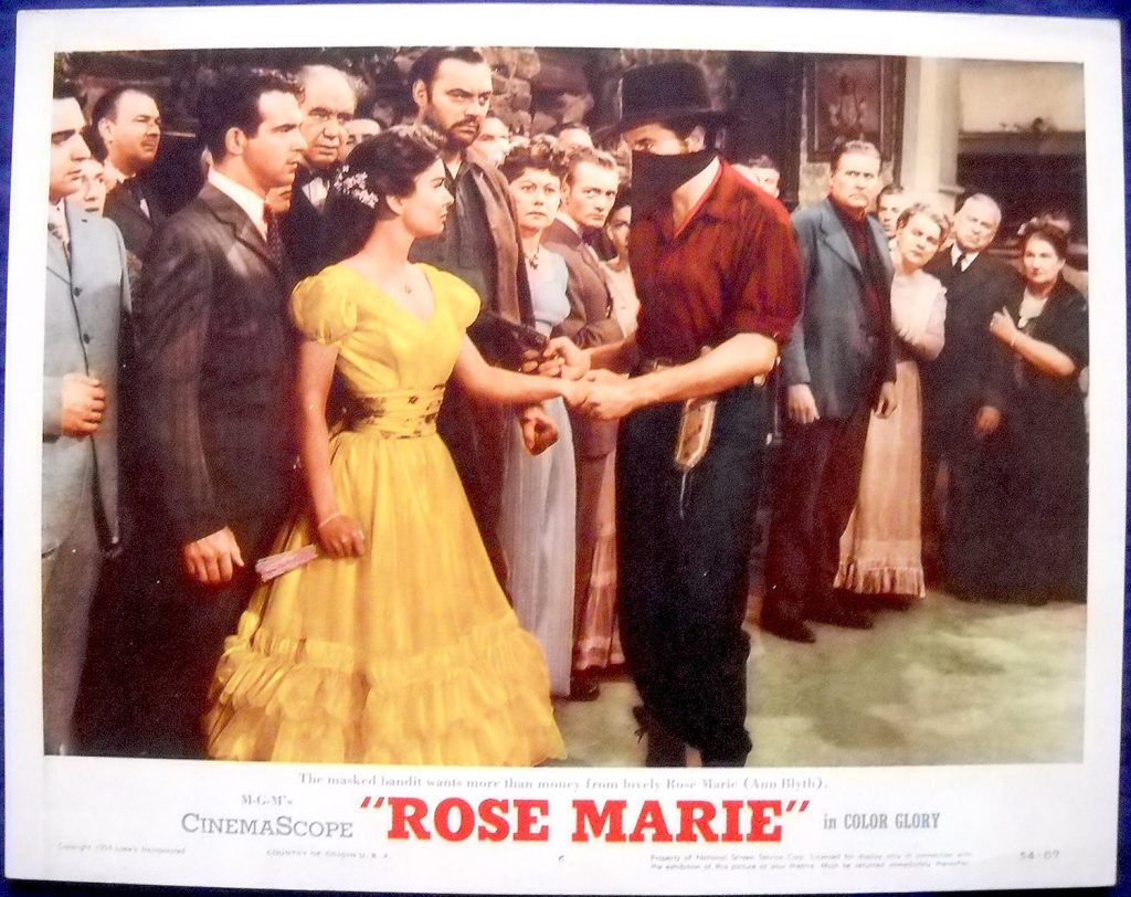 Movie poster from  Rose Marie, with Fernando Lamas and Ann Blyth on the left, and Howard Keel (wearing the robber mask) to the right